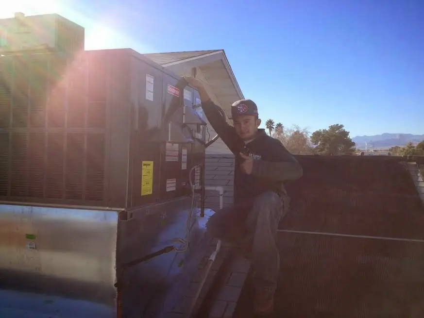 HVAC technician performing Boiler Repair on a rooftop unit in Tenafly